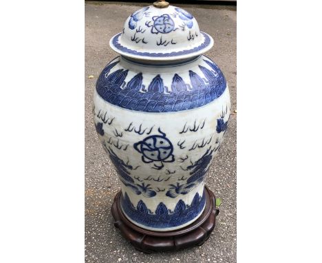 A LARGE 19TH CENTURY CHINESE BLUE AND WHITE CERAMIC LAMP BASE ON WOODEN STAND WITH DRAGONS CHASING THE FLAMING PEARL PATTERN 