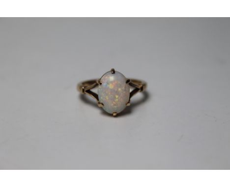 A 9 CARAT YELLOW GOLD OPAL RING, the central oval opal measuring 12 mm x 8.75 mm, ring size O 1/2 Buyers - for shipping prici