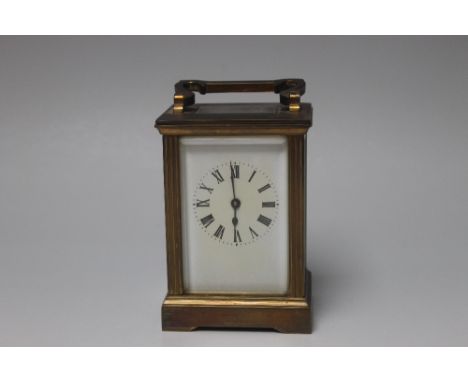 A SMALL BRASS CASED FRENCH CARRIAGE CLOCK, enamel face with Roman numerals, the brass case with fluted columns and four glass