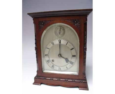 A MAHOGANY CASED MANTEL CLOCK - MOVEMENT BY J J ELLIOTT, the architectural case of simple form with carved floral spandrels a