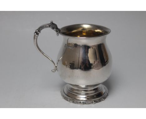 A HALLMARKED SILVER CHRISTENING TANKARD - BIRMINGHAM 1976, having Celtic style banded decoration to the base rim and Dragon h