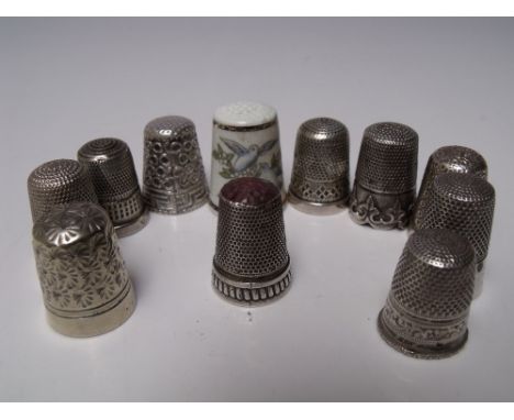 A COLLECTION OF SILVER AND WHITE METAL THIMBLES, together with a ceramic Royal Worcester example (11) Buyers - for shipping p
