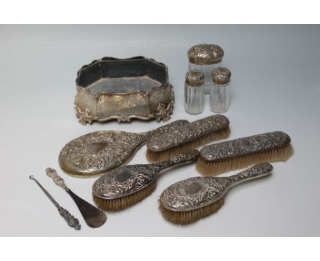 A HALLMARKED SILVER DRESSING TABLE COLLECTION, consisting of a four piece brush set, hand mirror, three toilet jars, a button