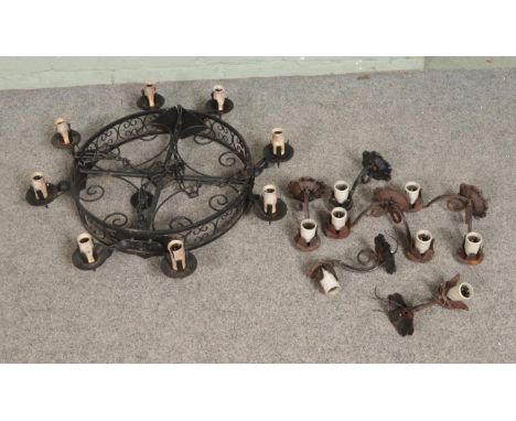 A wrought iron circular chandelier along with a collection of similar wall sconces, all converted to electric.  