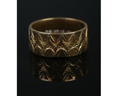 An 18ct Gold wedding band with waved decoration. Stamped 750 to the inside of the band. Size K½. Total weight: 6.5g  