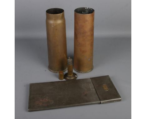 A collection of mostly military metalwares to include two artillery shells bearing broad arrow mark, trench art table lighter