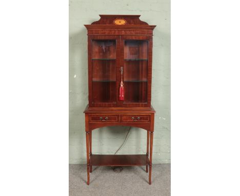 A mahogany display cabinet featuring shell fan pattern, glass shelving, built-in light and two drawers. Approx. dimensions 16