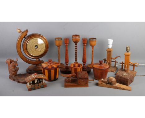A good collection of woodenwares, to include large candlesticks, cigarette dispenser, table lamps, double sided clock/baromet