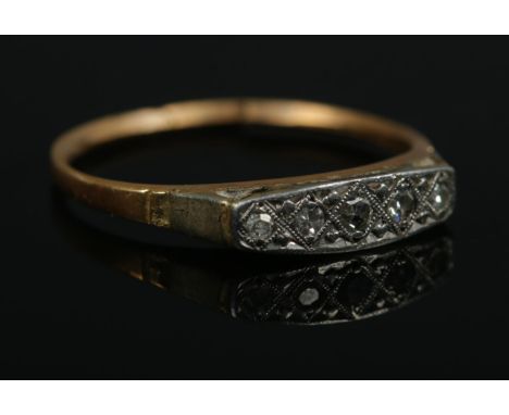 An 18ct Gold and Platinum five stone diamond ring; the stones set within an illusion setting. Size M½. Total weight: 1.9g.  B