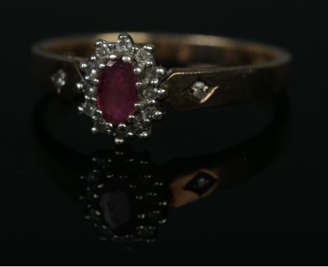 A 9ct gold ruby and diamond halo cluster ring with single diamond set shoulders. Size N, 2.2g.  