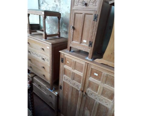 A 1930s limed oak bedroom suite comprising chest of drawers, tallboy, bedside cabinet, dressing table and stool. Some signs o