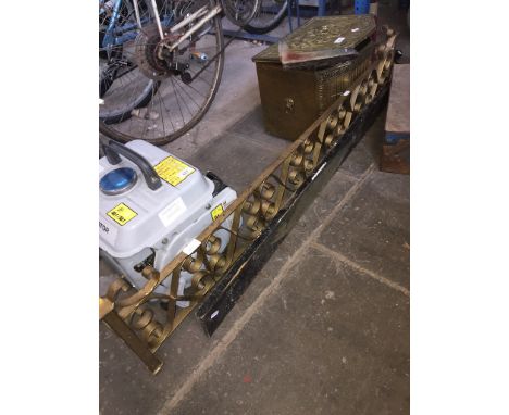 A wrought metal fender and a rack of hooks decorated with a prize fish, a brass covered coal slipper box and a fire front. 