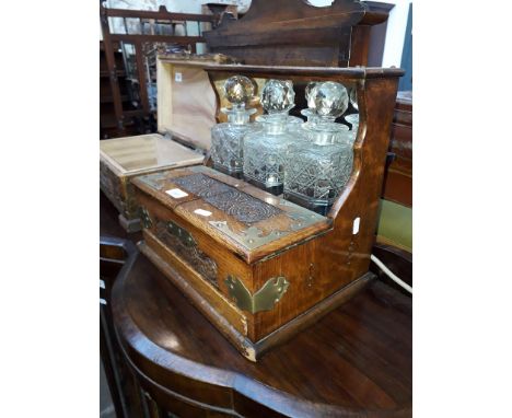 A Victorian oak tantalus with 3 decanters.Thanks for your enquiry. After inspection there is damage to the left top of this i