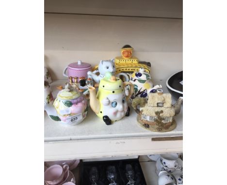 A novelty teapot in the form of a tank, with 7 others 