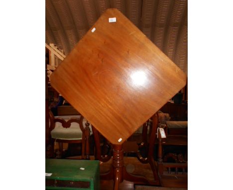 A Victorian tilt-top table the square top with canted corners, raised on a ring turned column supports and tripod base 