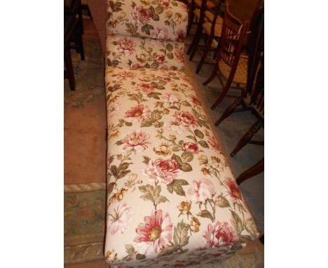 A floral upholstered day-bed with hinged seat and raised on brass and ceramic castors