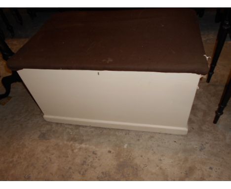 A painted pine trunk with internal candle drawer and upholstered top
