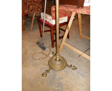 A Victorian brass oil standard lamp converted to electricity resting on large claw feet