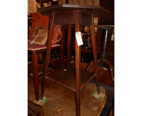 An Edwardian octagonal inlaid and chequer strung walnut lamp table raised on slender tapering supports and under tier