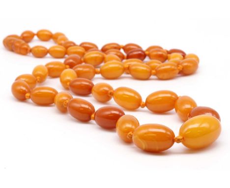 A single row graduated butterscotch amber bead necklace, the beads approximately 21 x 13mm to 10 x 7mm, strung knotted to an 