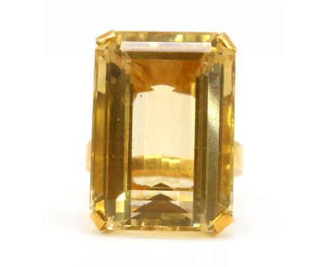 A gold single stone citrine ring, with an emerald cut citrine, 22.7 x 15.8mm, claw set to a flat section shank, tested as app