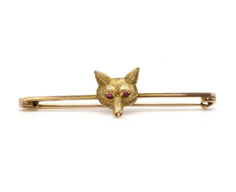 A gold fox head bar brooch, or stock pin, the fox head with cabochon ruby eyes, to a bar brooch, tested as approximately 9ct 