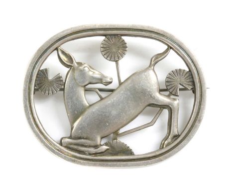 A sterling silver kneeling deer brooch, by Georg Jensen, model no. 256, designed by Arno Malinowski, the kneeling deer amongs