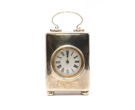 A sterling silver cased miniature travel clock, by Reichenberg &amp; Co., c.1900, of plain form with a simple loop handle, ci