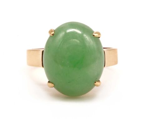 A gold single stone dyed jade ring, with an oval cabochon dyed jade, claw set, to open shoulders and a flat section shank, ma
