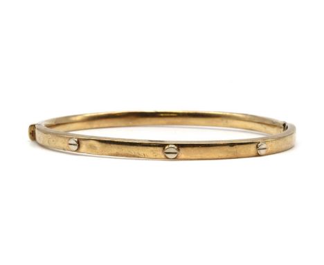 A gold hollow oval hinged bangle, with applied screw head detail, to hinge and box clasp, damaged, tested as approximately 9c