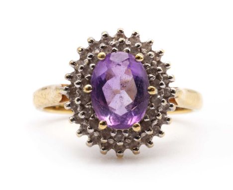 A gold amethyst and diamond cluster ring, with an oval mixed cut amethyst, approximately 8 x 6mm, claw set, to two row surrou