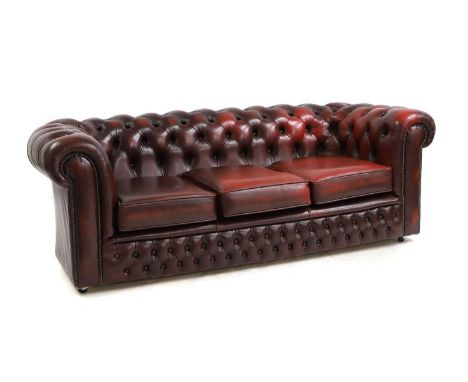 A red leather Chesterfield sofa, with studded detailing, and casters,185cm wide74cm deep60cm high