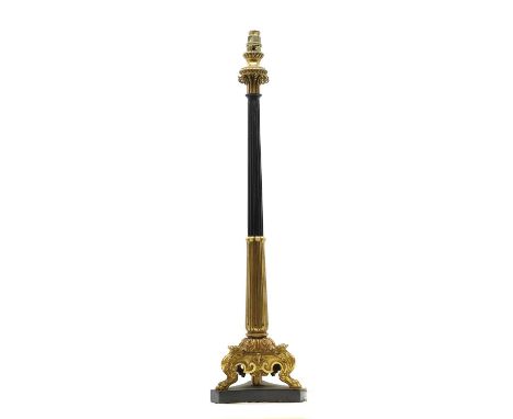 A neoclassical bronze and gilt bronze table lamp 19/20th century, the fluted column on a triform paw base and patinated platf