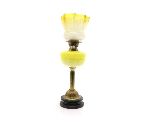 A Victorian brass oil lamp, with a yellow tinted shade, with a yellow glass reservoir, with a Duplex patent burner, 69cm high