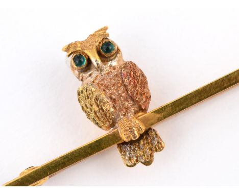 A THREE COLOUR GOLD OWL BROOCH. realistically formed, with emerald eyes, 5cm long.  **BP 22.5% inc VAT + Lot Fee of £8  