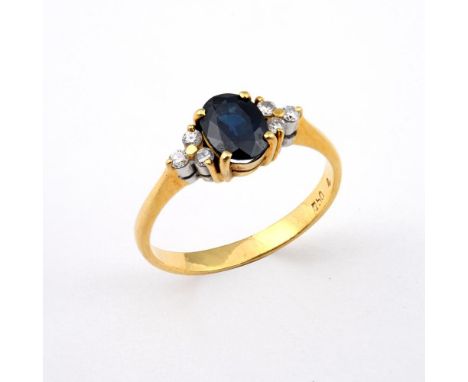 A SAPPHIRE AND DIAMOND RING. the oval-shaped sapphire is set with three circular-cut diamonds to each shoulder, in 18ct gold.