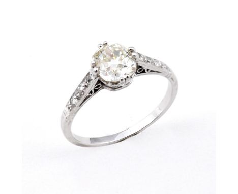 A DIAMOND SOLITAIRE RING. the cushion-shaped old-cut diamond is set with three rose-cut diamonds to each shoulder. Size N.  *
