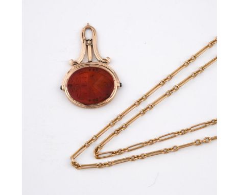A CORNELIAN AND GOLD SPINNING FOB SEAL. engraved with a coat of arms to one side and a monogram to the other, 5cm long, toget