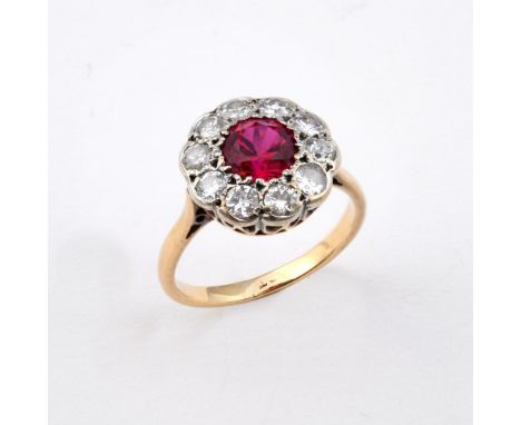 A SYNTHETIC RUBY AND DIAMOND CLUSTER RING. the circular-cut synthetic ruby is set within a surround of circular-cut diamonds,