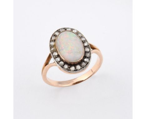 AN OPAL AND DIAMOND CLUSTER RING. the oval-shaped white opal is set within a surround of rose-cut diamonds, in gold. Size O. 