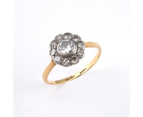 A DIAMOND CLUSTER RING. of flowerhead from, set with circular old-cut diamonds in 18ct gold and platinum. Size M1/2.  **BP 22