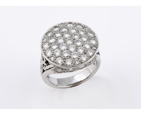 A DIAMOND CLUSTER RING. pave set with circular-cut diamonds, with further circular-cut diamonds set to the sides, weighing ap