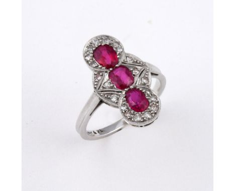 A RUBY AND DIAMOND TRIPLE CLUSTER RING. the three oval-shaped rubies are set within a surround of millegrain set circular-cut