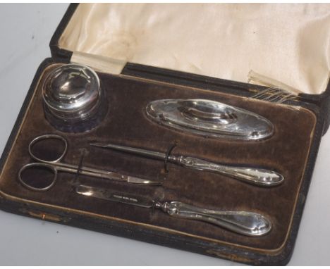 A cased manicure set comprising: silver mounted dressing table jar and buffer; silver handled cuticle tools, marked for Birmi