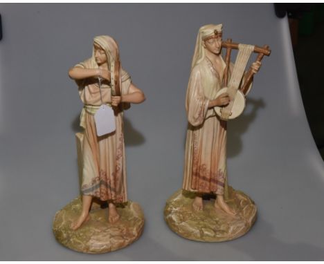 A pair of James Hadley Worcester porcelain figures of Eastern Musicians, in blush ivory, one holding a tambourine, the other 