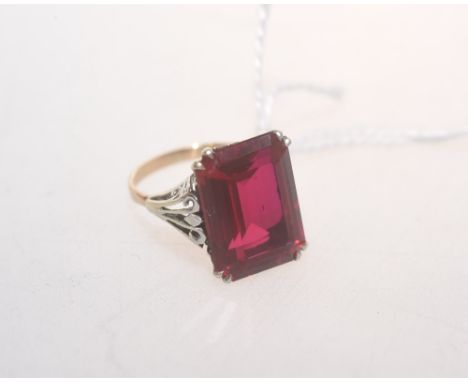 A faux ruby dress ring emerald cut and mounted in white and yellow metal, size K 1/2