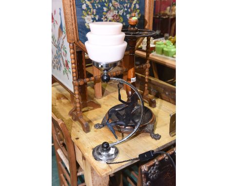 An early 20th century figural chrome table lamp in the Art Deco taste fitted with a glass shade