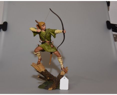 A Royal Doulton figure of Robin Hood standing on a branch with his bow and arrow