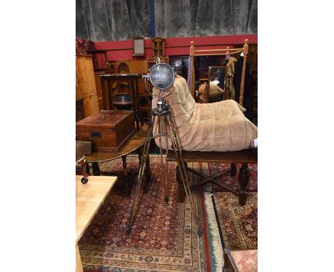 A vintage chrome studio lamp on a tripod base