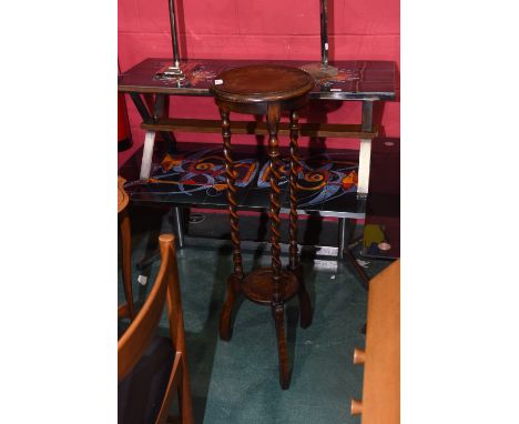 An early 20th Century jardiniere stand the circular top with barley twist supports with ciruclar shelf and on three shaped fe